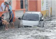  ?? RAFAEL POLO ?? Dos jóvenes amarran un vehículo para que no sea arrastrado por la corriente.