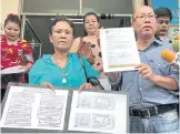  ??  ?? A woman holds a chart explaining how she was falsely accused by two women of embezzling winning lottery tickets from them in a complaint lodged with Udon Thani police last year. The woman, who gave her name only as Jaroon, yesterday filed a police...