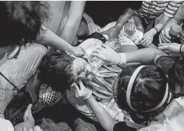  ?? ANTHONY WALLACE/GETTY-AFP ?? Volunteer medics help a bystander after police fired tear gas Sunday in the Mong Kok district of Hong Kong. The city was gripped by another day of petrol bombs and tear gas as police and protesters clashed for hours throughout a popular tourist district.