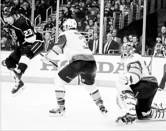  ?? CHRIS CARLSON THE ASSOCIATED PRESS ?? Kings right-winger Dustin Brown, left, jumps out of the way of the puck as it goes between the legs of Golden Knights defenceman Brayden McNabb as Vegas goaltender Marc-Andre Fleury looks on.