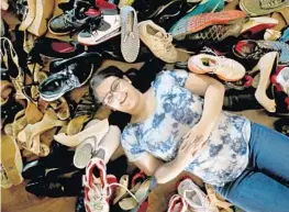  ?? MIKE STOCKER/STAFF PHOTOGRAPH­ER ?? Tiernan Ramer, 17, of Plantation, with hundreds of shoes she is about to give away. “Shoes are the key to walking with confidence,” said Tiernan, a senior at South Plantation High.