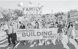  ?? Rick Bowmer / Associated Press files ?? Members of Mormons Building Bridges share their support for the LGBT community during the 2013 Utah Gay Pride Parade in Salt Lake City. Gay and lesbian Mormons and their supporters are reeling over the church’s rule changes announced Thursday.