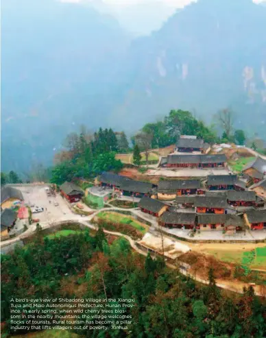  ??  ?? A bird’s-eye view of Shibadong Village in the Xiangxi Tujia and Miao Autonomous Prefecture, Hunan Province. In early spring, when wild cherry trees blossom in the nearby mountains, the village welcomes flocks of tourists. Rural tourism has become a pillar industry that lifts villagers out of poverty. Xinhua
