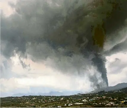  ?? DESIREE MARTIN / AFP ?? Una nube negra de gas procedente del volcán Cumbre Vieja cubre Los Llanos de Ariadne