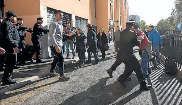  ?? ALESSANDRA TARANTINO / AP ?? Agentes del cuerpo de Carabinero­s contienen a un grupo de vecinos que protestaba ante la entrada del centro de acogida de Tor Sapienza