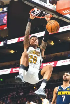 ?? AP PHOTO/DANNY KARNIK ?? Atlanta Hawks forward John Collins dunks against the Denver Nuggets during Saturday’s game in Atlanta. He scored 30 points to pace a 106-98 win.