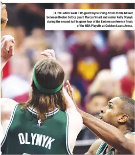  ??  ?? CLEVELAND CAVALIERS guard Kyrie Irving drives to the basket between Boston Celtics guard Marcus Smart and center Kelly Olynyk during the second half in game four of the Eastern conference finals of the NBA Playoffs at Quicken Loans Arena.