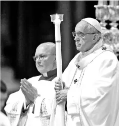  ?? — Reuters photo ?? Pope Francis holds a candle as he leads the Easter vigil mass in Saint Peter’s Basilica at the Vatican.