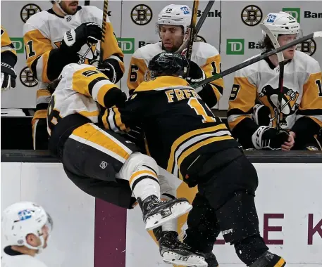  ?? MATT sTonE / HErAld sTAFF ?? ROUGH AND TUMBLE: Bruins forward Trent Frederic shoves Kris Letang of the Pittsburgh Penguins into the bench during their game at the TD Garden on Thursday night.