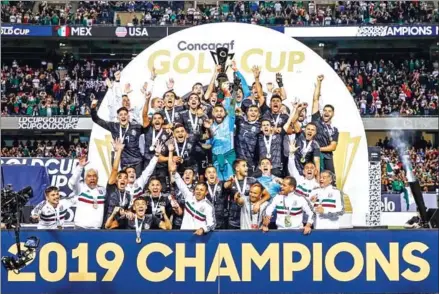  ?? CLAUS ANDERSEN/GETTY IMAGES/AFP ?? Mexico players and coaches celebrate with the Gold Cup after beating the US in the 2019 Concacaf Gold Cup final between USA and Mexico on Sunday at Soldier Field stadium in Chicago, Illinois.