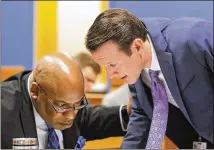  ??  ?? Prosecutor­s Clint Rucker (left) and AdamAbbate confer during the hearing that addressed severalmot­ions in the case of Claud “Tex” McIver, who is charged withmurder in the shooting death of hiswife.