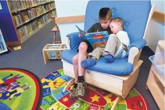  ?? MARLA BROSE/JOURNAL ?? Nathaniel Pena, 7, reads to his brother Ari, 3, at Tony Hillerman Library during the kick-off for this summer’s program, “Libraries Rock!”