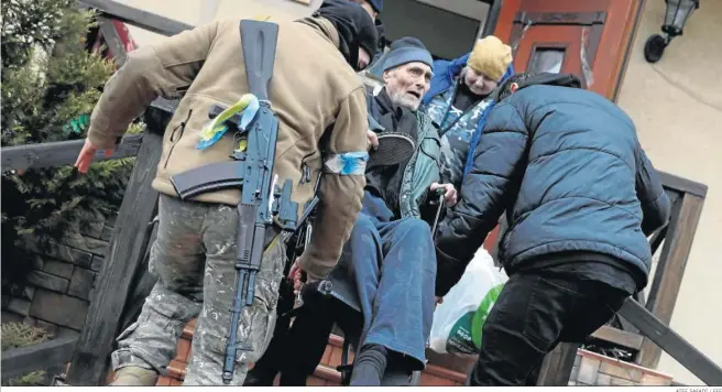  ?? ATEF SAFADI / EFE ?? El personal de Defensa Territoria­l de Ucrania ayuda ayer a evacuar a los ancianos de un refugio en la ciudad de Irpin.