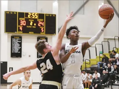  ?? PHOTOS BY CHRIS RILEY — TIMES-HERALD ?? American Canyon’s Gabriel Patrick goes up against Will Coolidge from Windsor during the Wolves’ 73-68win on Tuesday.