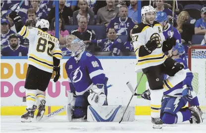  ?? AP PHOTOS ?? STARS SHINE: David Pastrnak (88, above) celebrates a goal by Patrice Bergeron (37) during the second period of the Bruins’ 6-2 rout of the Lightning in Game 1 yesterday in Tampa. At right, Bergeron hugs Brad Marchand after scoring his second of the...