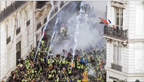  ??  ?? ‘Yellow vests’ protesters clash with riot police amid tear gas on the Champs Elysees in Paris. — AFP photo