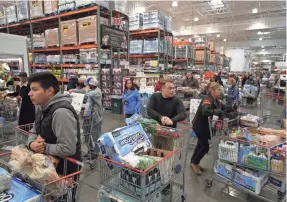  ?? JUSTIN SULLIVAN/GETTY IMAGES ?? Customers wait in long lines to check out on Saturday at a Costco store in Novato, Calif.