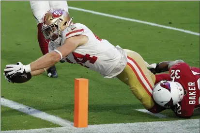  ?? PHOTOS BY RICK SCUTERI — THE ASSOCIATED PRESS ?? San Francisco 49ers fullback Kyle Juszczyk (44) dives in for a touchdown as Cardinals strong safety Budda Baker (32) defends during the second half on Saturday in Glendale, Ariz.