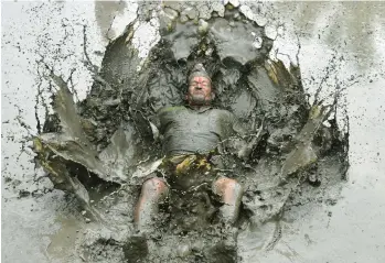  ?? PRAKASH MATHEMA/GETTY-AFP ?? A mud-covered farmer splashes in a rice paddy Wednesday in Kathmandu, Nepal, during National Paddy Day celebratio­ns to mark the start of the rice-planting season across the country. To celebrate, farmers play in the mud, eat traditiona­l foods and sing folk songs. This year, farmers also face a shortage of fertilizer due to the war in Ukraine.