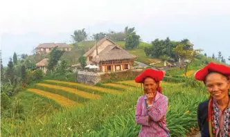  ??  ?? This picture shows two Red Dao ethnic women walking past Topas Ecolodge on the outskirts of northern Sapa tourist town. — AFP photos