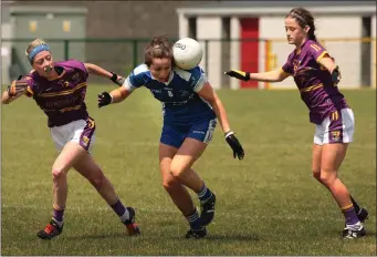  ??  ?? Jane Moore of Laois performs a balancing act as Kellie Kearney and Ellen O’Brien apply pressure.