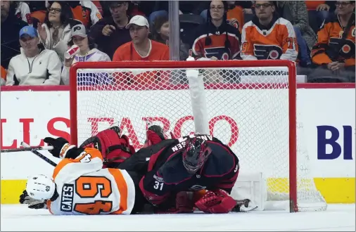  ?? MATT SLOCUM — THE ASSOCIATED PRESS ?? The Flyers’ Noah Cates collides with Carolina Hurricanes goalie Frederik Andersen during the third period Saturday at Wells Fargo Center.