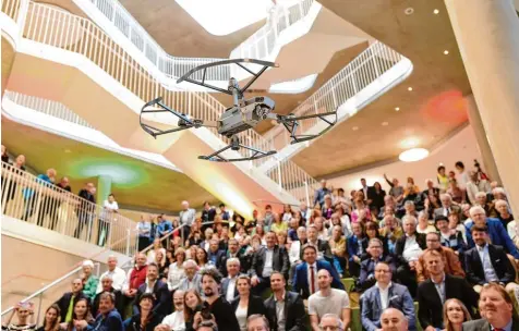  ?? Fotos: Marcus Merk ?? Die mehreren Hundert Festgäste bei der Einweihung der Mittelschu­le Gersthofen schauten gebannt auf die Drohne, die statt des traditione­llen Schlüssels den Öffnungs Chip für die Schließanl­age in die große Aula transporti­erte.