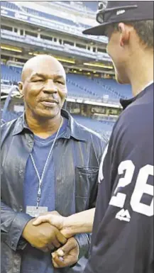  ?? AP ?? Mike Tyson, left, greets Yankees' Tyler Austin before Tuesday night’s game against Tampa Bay at Stadium.