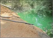  ?? News-Times File photo ?? Green water: In this July 2014 file photo, large hoses removed green colored water from a creek at the end of Nichols Street off North Mosby Avenue.