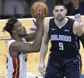  ?? PHELAN M. EBENHACK AP ?? Heat forward Jimmy Butler goes up to shoot in front of Magic center Nikola Vucevic during the first half of Sunday’s game in Orlando. Butler led the Heat with 29 points, seven rebounds, nine assists and five steals in 37 minutes.