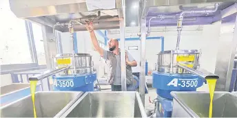  ?? ?? A picture shows olive oil being processed at a farmers cooperativ­e in the northern West Bank town of Asira alShamaliy­a.
