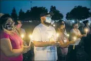  ?? Andrew Kuhn Merced Sun-Star BY JIE JENNY ZOU, ANDREA CASTILLO AND ERIN B. LOGAN ?? FOSTER FARMS employee Kevin Vera, center, at a vigil to honor workers who died of COVID-19.