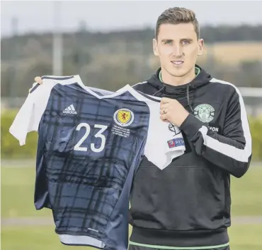  ??  ?? 0 Paul Hanlon poses with one of Steven Whittaker’s Scotland strips at East Mains yesterday.