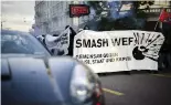  ?? ?? Protesters walk with a banner reading "Smash WEF" past a sports car during a demonstrat­ion against the World Economic Forum (WEF) in Zurich, Switzerlan­d, Friday, May 20, 2022. Michael Buholzer/Keystone via AP