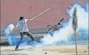  ?? WASEEM ANDRABI/HT ?? A student hurling an exploded tear smoke canister at police during a protest in Srinagar on Tuesday.