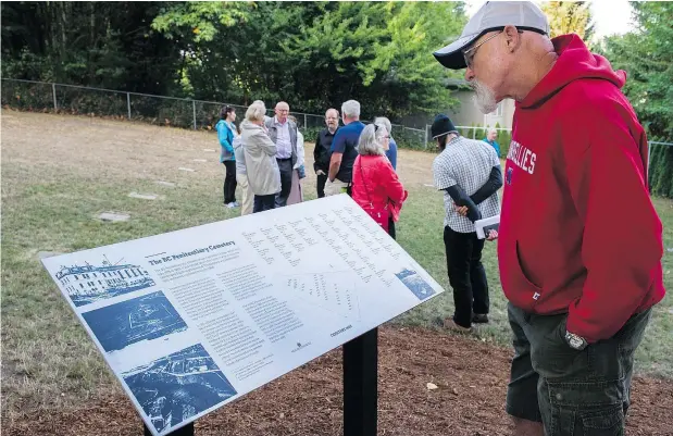  ?? GERRY KAHRMANN /PNG ?? Duncan Shanks checks out the sign and map at the entrance to the restored B.C. Penitentia­ry Cemetery in New Westminste­r. Dozens of prisoners were buried there between 1913 and 1968 after their bodies went unclaimed by friends or family.