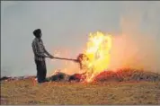  ??  ?? A farmer burning paddy stubble at his farm in Punjab.
FILE PHOTO