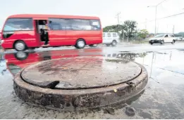  ?? GLADSTONE TAYLOR/MULTIMEDIA PHOTO EDITOR ?? Numerous manhole covers like this one, elevated above the corridor’s surface, can be seen along Constant Spring Road, St Andrew. The exposed covers will continue to be a nuisance to motorists until a final layer of asphalt is added to the roadway. The US$19-billion Constant Spring Road Improvemen­t Project is slated to end this summer, the National Works Agency has said.