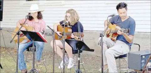  ?? PHOTOS BY LYNN KUTTER ENTERPRISE-LEADER ?? Patience Remington, of Lincoln, left, Peyton Orona of Prairie Grove and Jacob Phaneuf, owner of Inside Out Studio in Farmington, play at the Prairie Grove Farmers Market. The two girls are part of a program called Roots Music, sponsored through the studio by Historic Cane Hill.