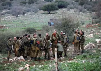  ?? (Amir Cohen/Reuters) ?? SOLDIERS GATHER in a field near the Lebanese border last month.