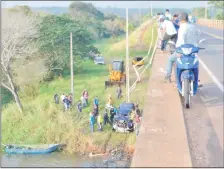  ??  ?? Bomberos y vecinos sacan con ayuda de un tractor la camioneta Nissan, en la que murió ahogada la estudiante.