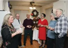  ?? ANDREW FRANCIS WALLACE PHOTOS/TORONTO STAR ?? Writer Vicky Sanderson, left, and party guests enjoy a laugh in her 9-by-12-foot kitchen with finger foods and drinks near at hand.