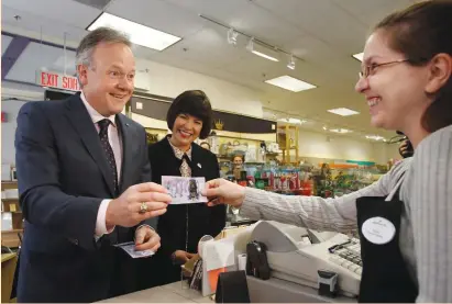  ?? (Chris Wattie/Reuters) ?? BANK OF CANADA Governor Stephen Poloz pays for an item with a commemorat­ive $10 banknote celebratin­g the 150th anniversar­y of Canada’s confederat­ion yesterday at a store in Ottawa.