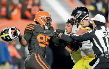  ?? AP ?? Cleveland Browns defensive end Myles Garrett, left, gets ready to hit Pittsburgh Steelers quarterbac­k Mason Rudolph, second from left, with a helmet.