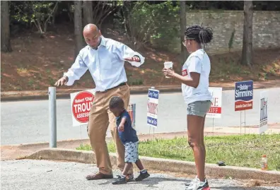  ??  ?? Danielle Inez, right, the campaign manager for Democrat Lee Harris, watches as Harris plays with her 3-year-old son, Joseph, in front of Shady Grove Elementary School on Election Day on Tuesday. Harris is running for Shelby County Mayor. YALONDA M. JAMES / THE COMMERCIAL APPEAL