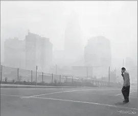  ?? John Malmin
Los Angeles Times ?? LOS ANGELES BUILDINGS are barely visible looking east at 1st and Olive streets on Sept. 13, 1955, when ozone levels broke records.