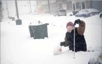  ?? Mark Makela Getty Images ?? ATLANTIC CITY, N.J. Thom Meyers, 67, uses a cane to traverse snow-covered streets. Meteorolog­ists say the storm originated in the South. The forecast calls for more frigid cold in the Northeast, with temperatur­es in the single digits and teens in many...