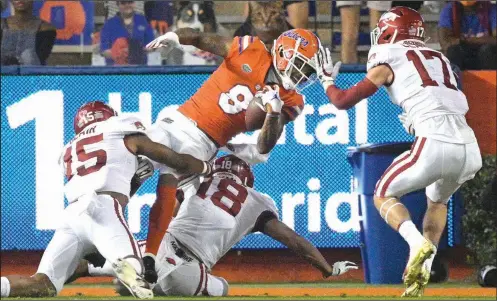  ?? More photos at arkansason­line.com/1115razorb­acks/ (AP/Phelan M. Ebenhack) ?? Florida wide receiver Trevon Grimes scores on a 9-yard reception among Arkansas defenders Simeon Blair (15), Myles Mason (18) and Hudson Clark (17) during the first half Saturday in Gainesvill­e, Fla. It was one of five first-half touchdowns for Gators quarterbac­k Kyle Trask, who threw for 356 yards and six touchdowns overall in Florida’s 63-35 victory.