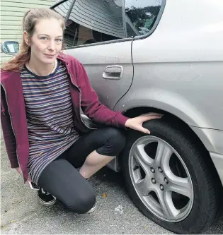  ?? PHOTO: RICHARD DAVISON ?? Disappoint­ed . . . Clyde St, Balclutha, resident Ashlee Marshall inspects a tyre on her family car, one of multiple vehicles whose tyres were deliberate­ly punctured on Sunday night.