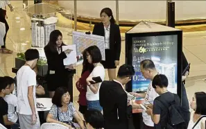  ??  ?? Sales personnel attending to potential property buyers at the GIC booth during the fair at Queensbay Mall in April.